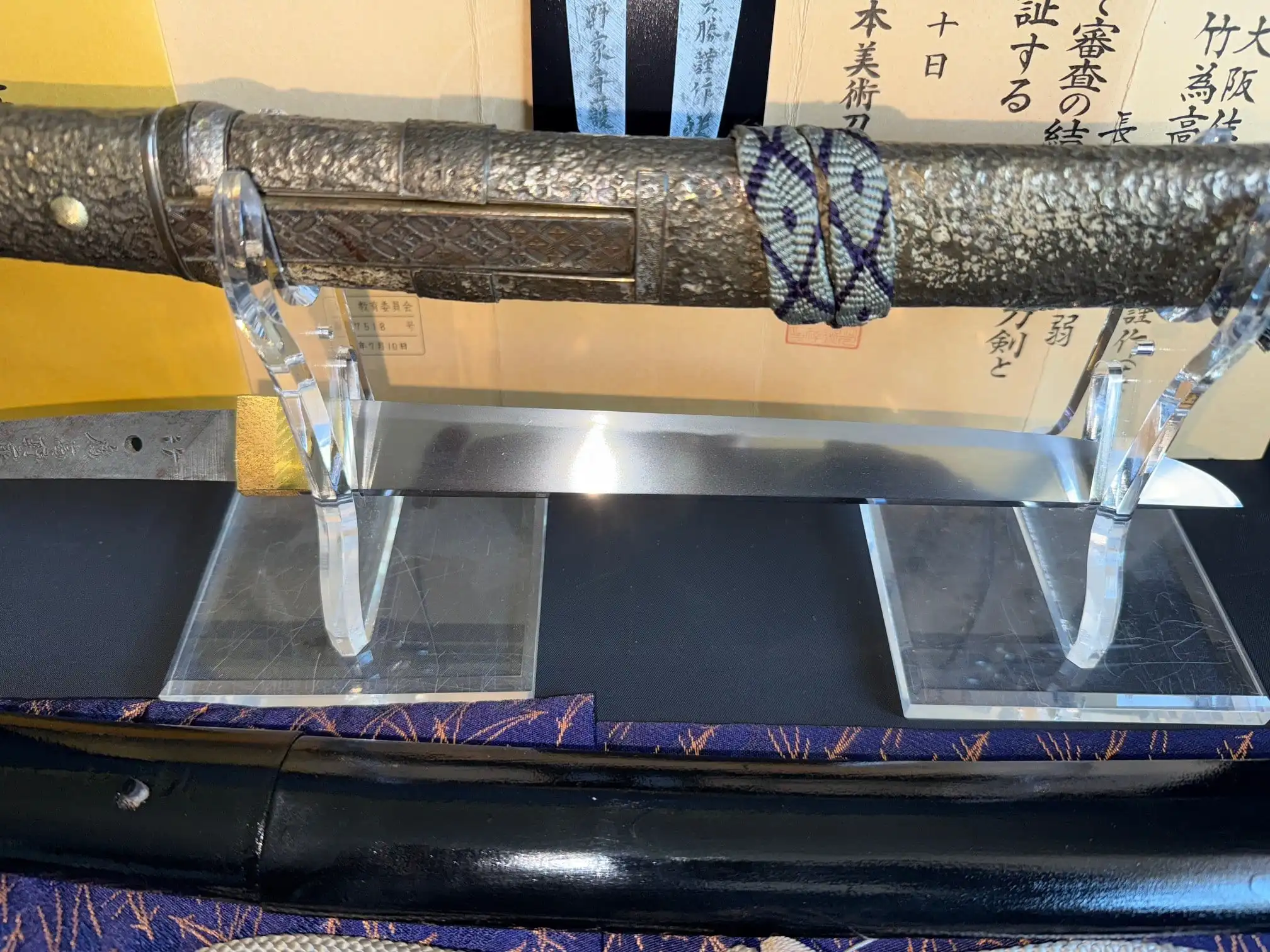 Tanto Gassan Sadakatsu, a Japanese masterpiece Tanto, blade displayed on stand with ornate handle and paperwork