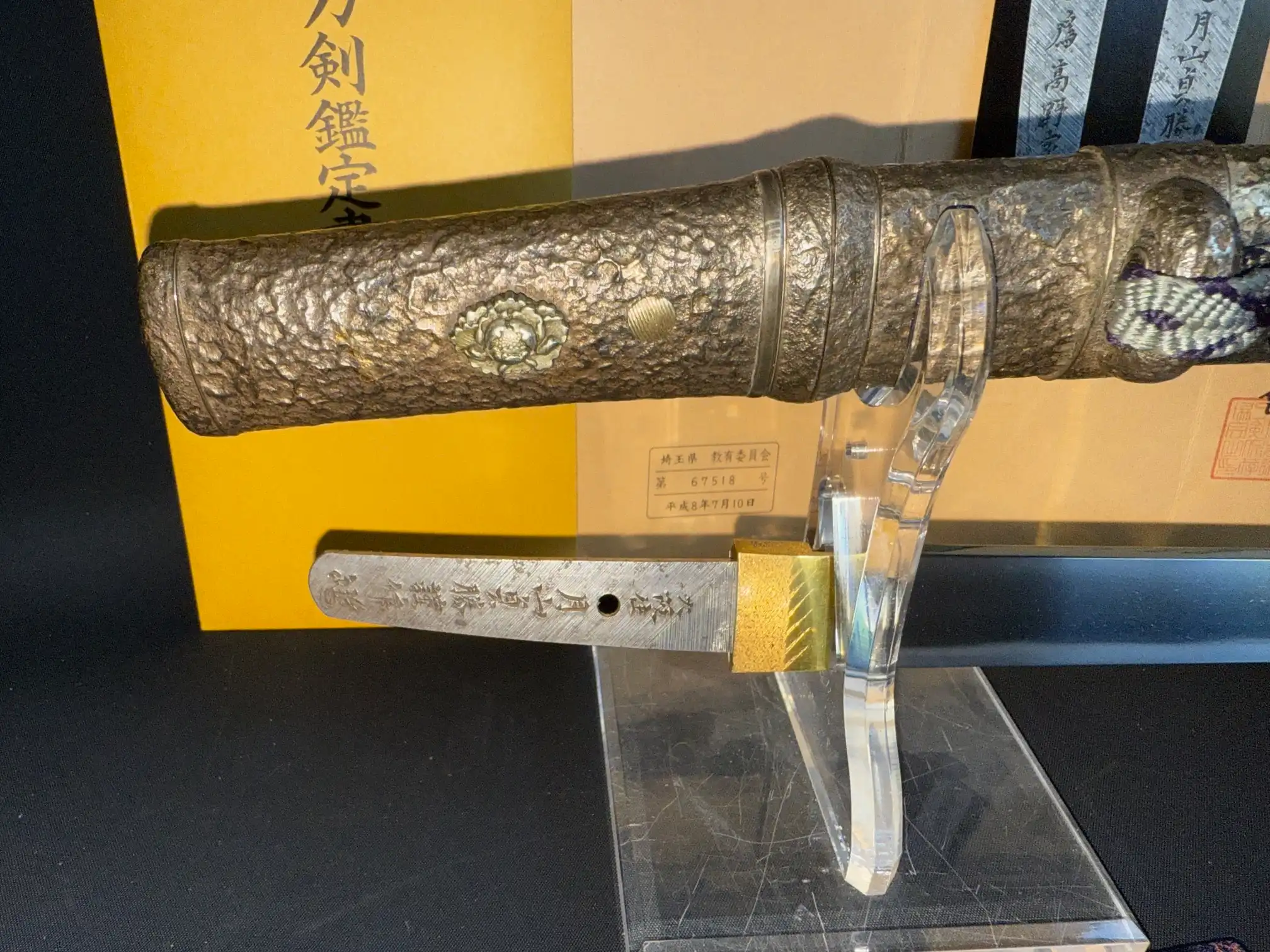 Tanto Gassan Sadakatsu, an antique Japanese short sword with visible nakago and koshirae, displayed on a stand
