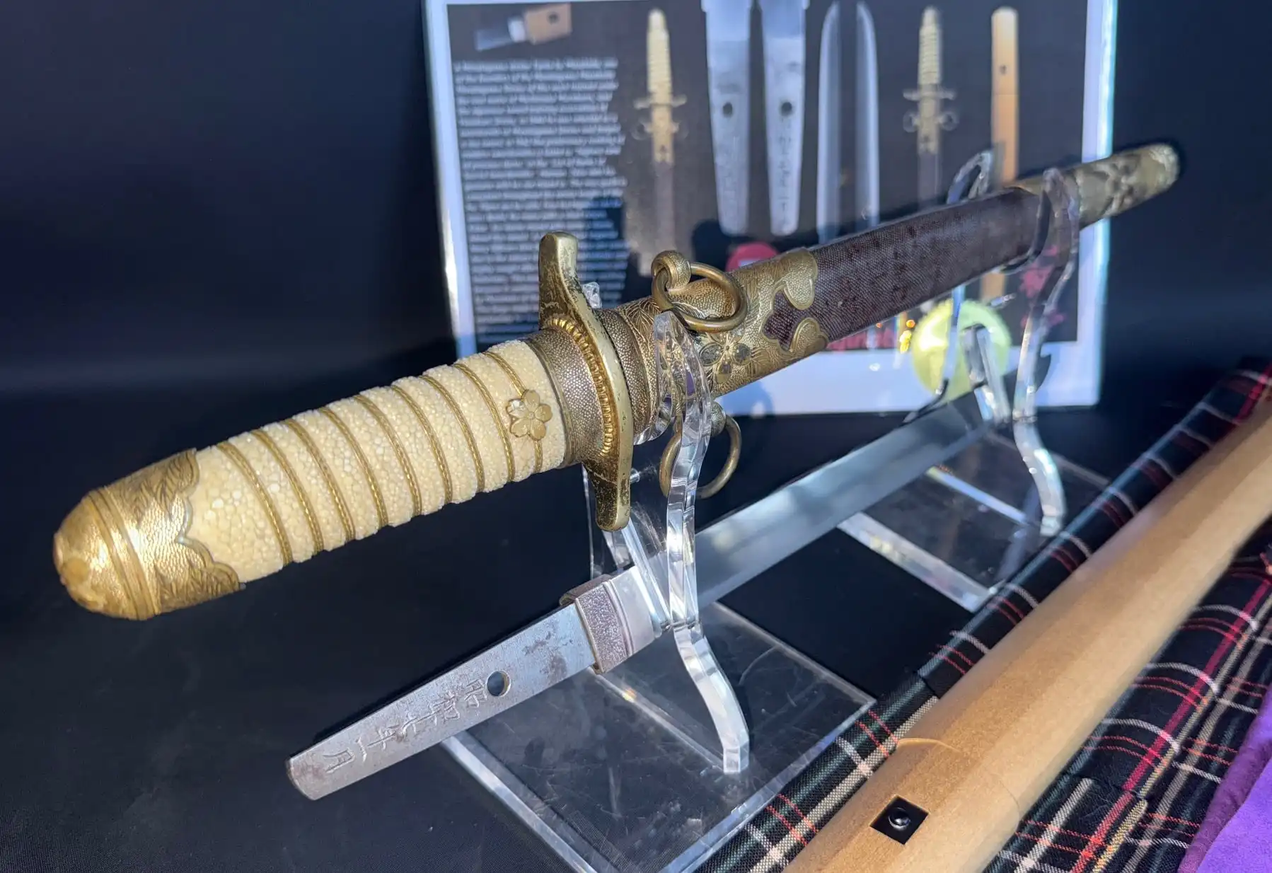 Minatogawa Tanto Masatada, detailed view of the koshirae and blade, resting on a display stand.