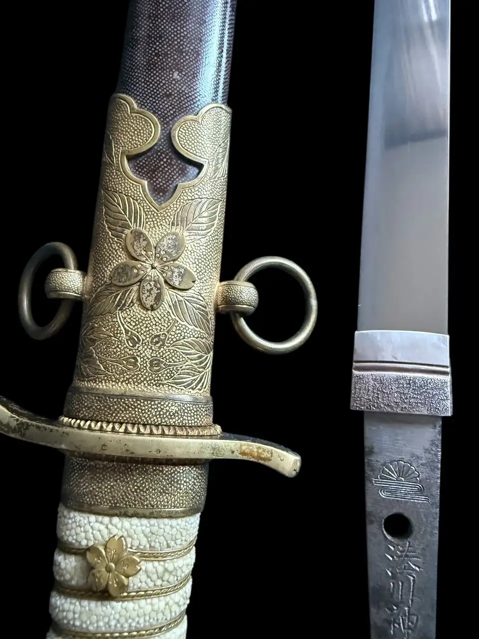 Detailed hilt of Minatogawa Tanto Masatada, a Japanese antique tanto with gilt floral fittings and stingray skin