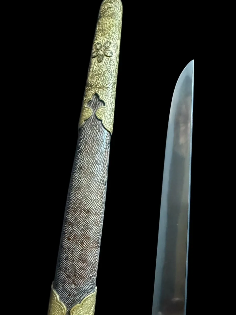 Close-up of a Minatogawa Tanto Masatada, showing the decorative floral koshirae and part of the blade