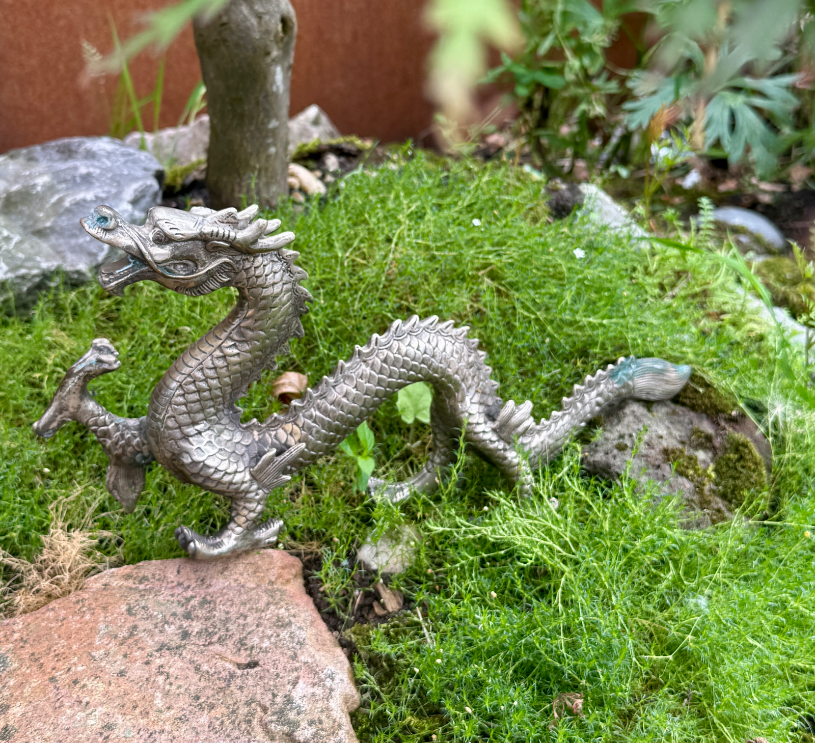Japanese Silvered Dragon Sculpture Meiji Period style with blue eyes, katana category, on mossy ground