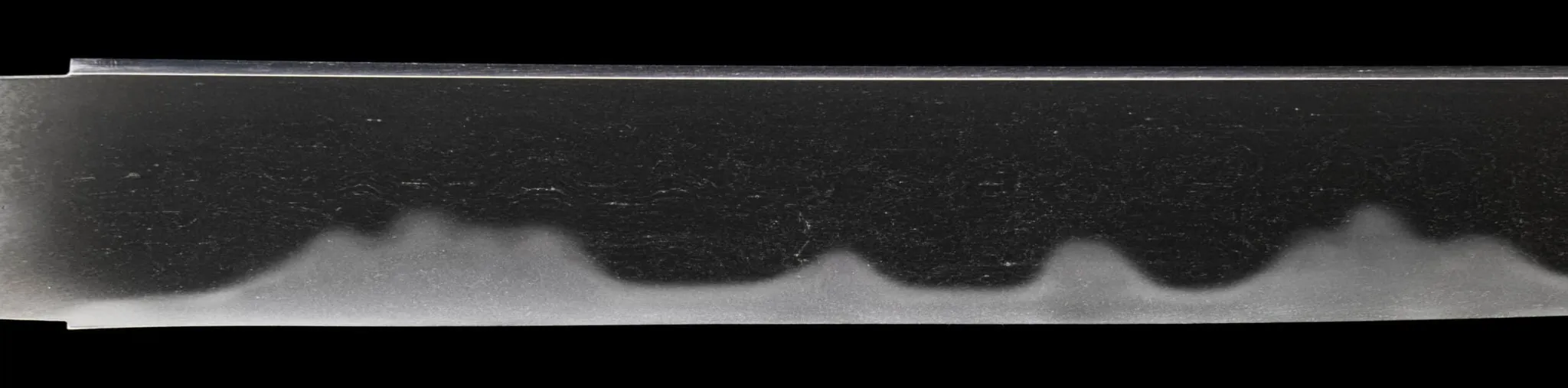 Close-up of the wavy tempered edge (hamon) on a Muramasa Demon Steel Tantō, a Japanese short sword