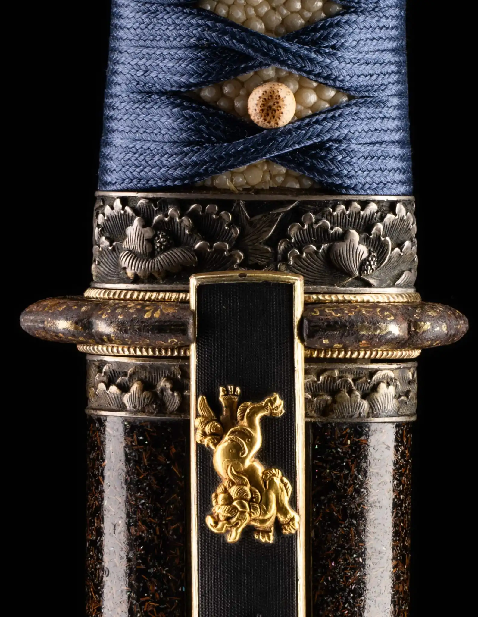 Closeup of a Tantō Muramasa Demon Steel showing the blue tsuka-ito, ray skin, and gold shishi fuchi-kashira.