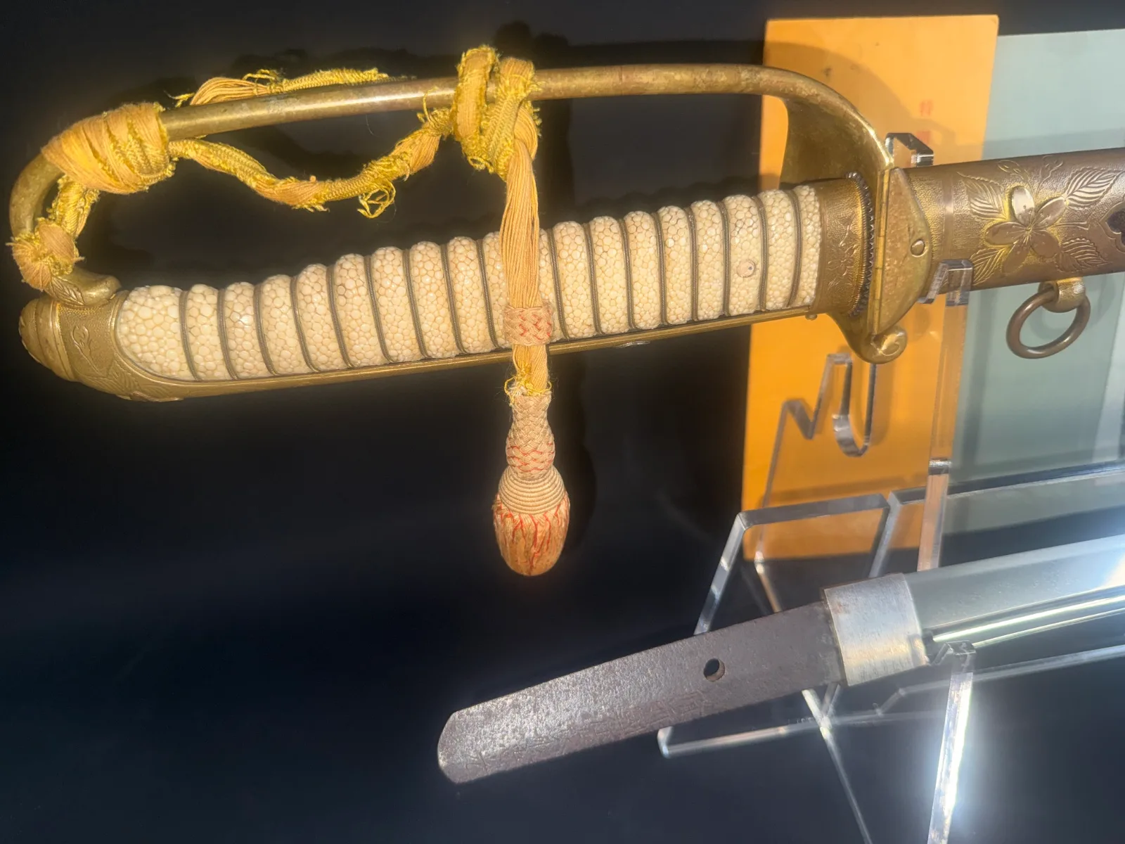 Naruse Family Heirloom katana hilt with white ray skin, golden guard, tassel, and visible tang detail.