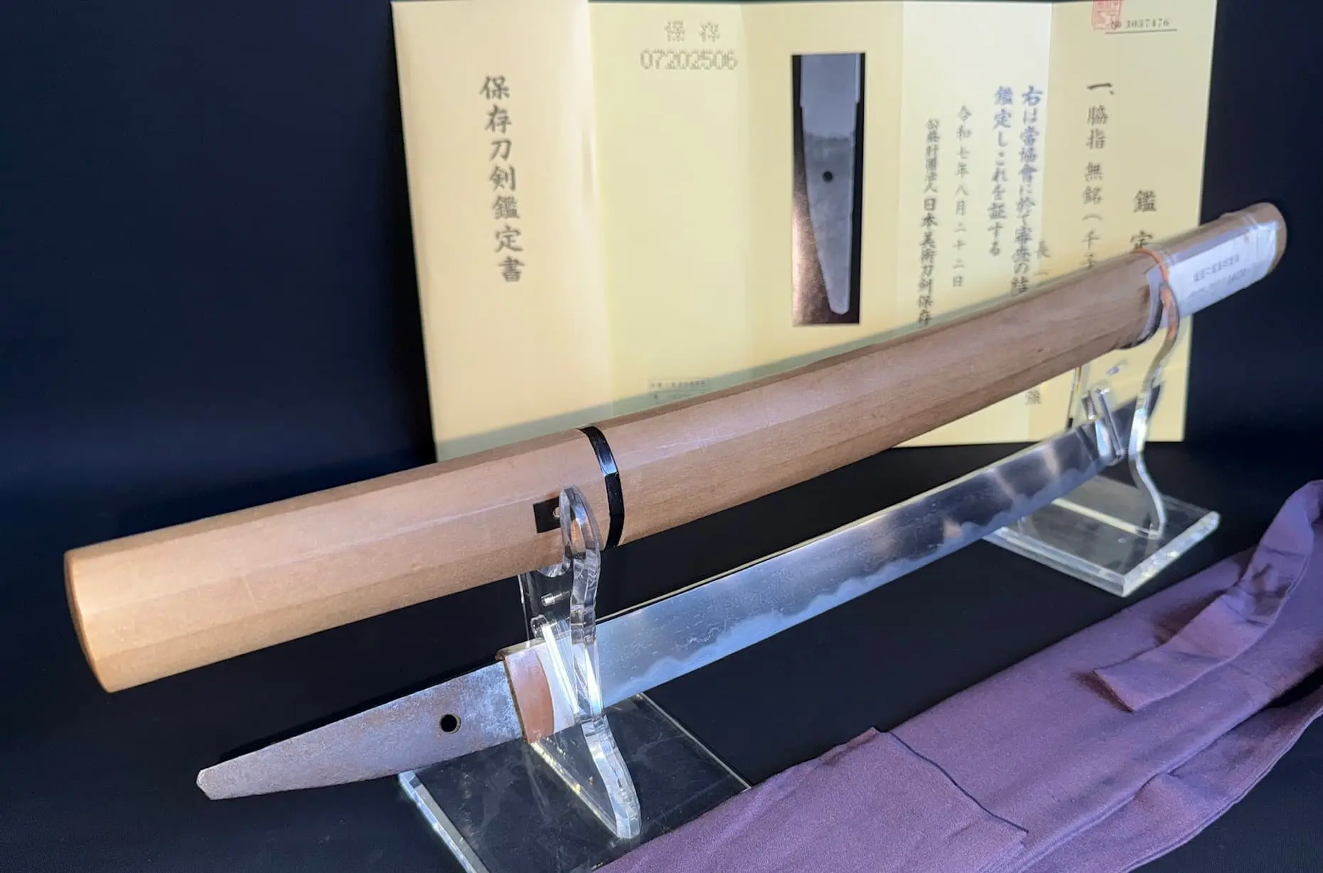 Close-up Mumei Wakizashi Sengo Muramasa, blade visible with wooden saya and NBTHK Hozon Tokken certificate