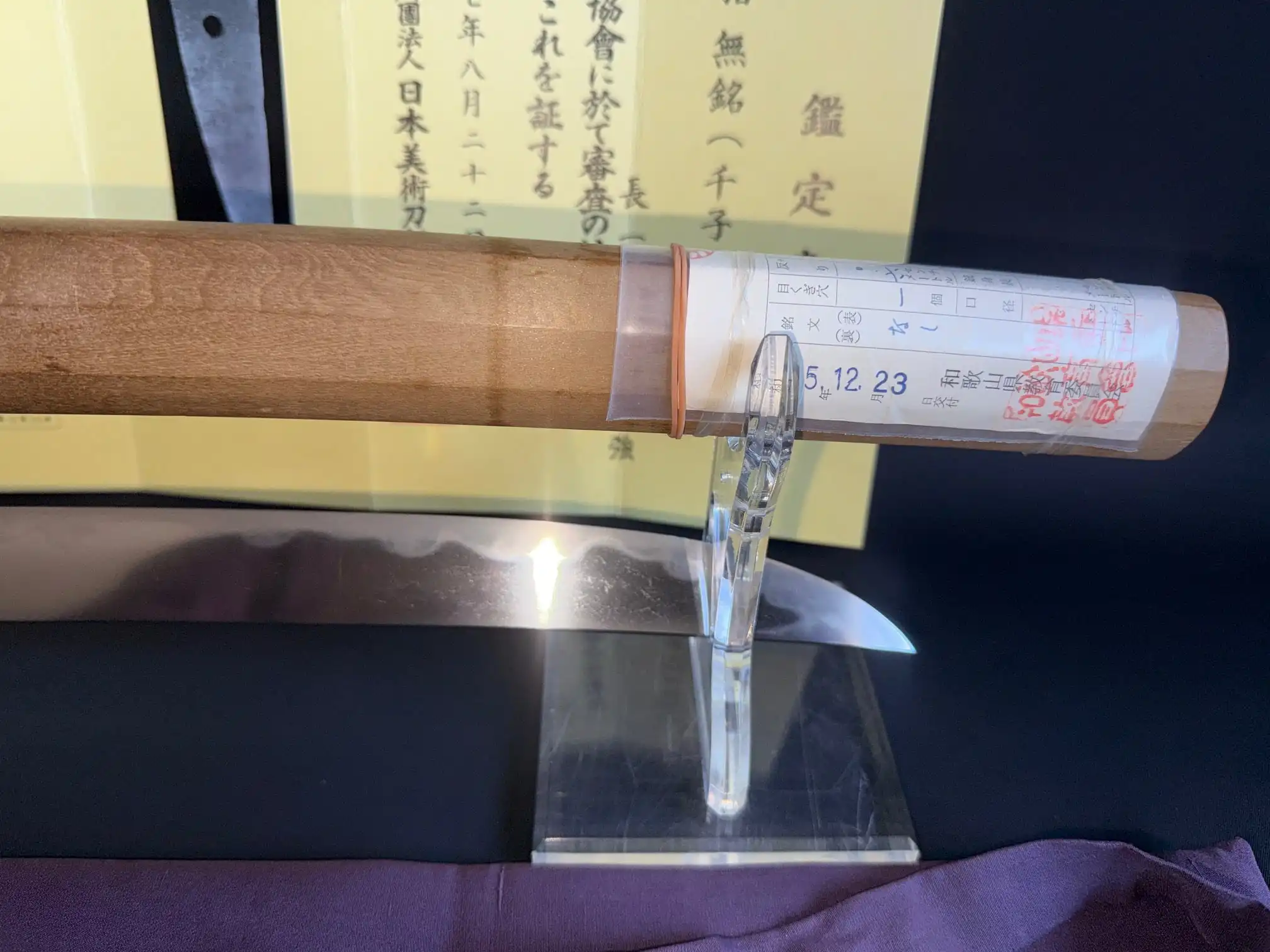 Close-up of Mumei Wakizashi Sengo Muramasa blade and certificate on display.