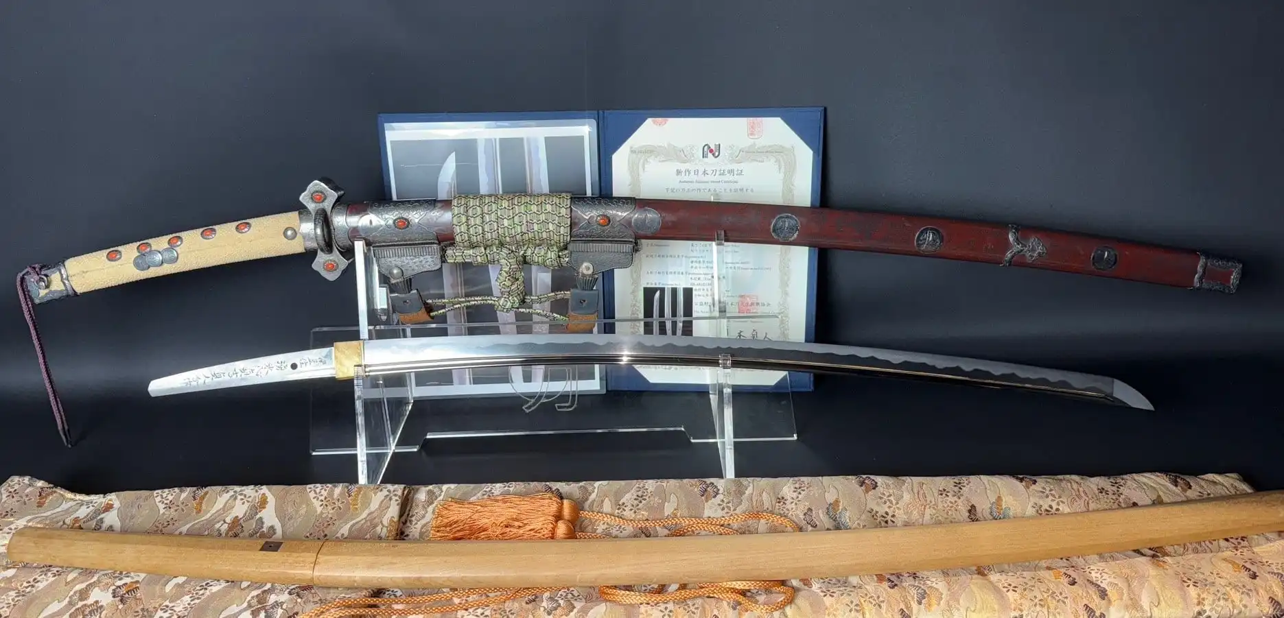 Tachi Katana Sadayoshi/Sadahito, a Japanese katana with decorated scabbard and exposed blade, certificate behind.