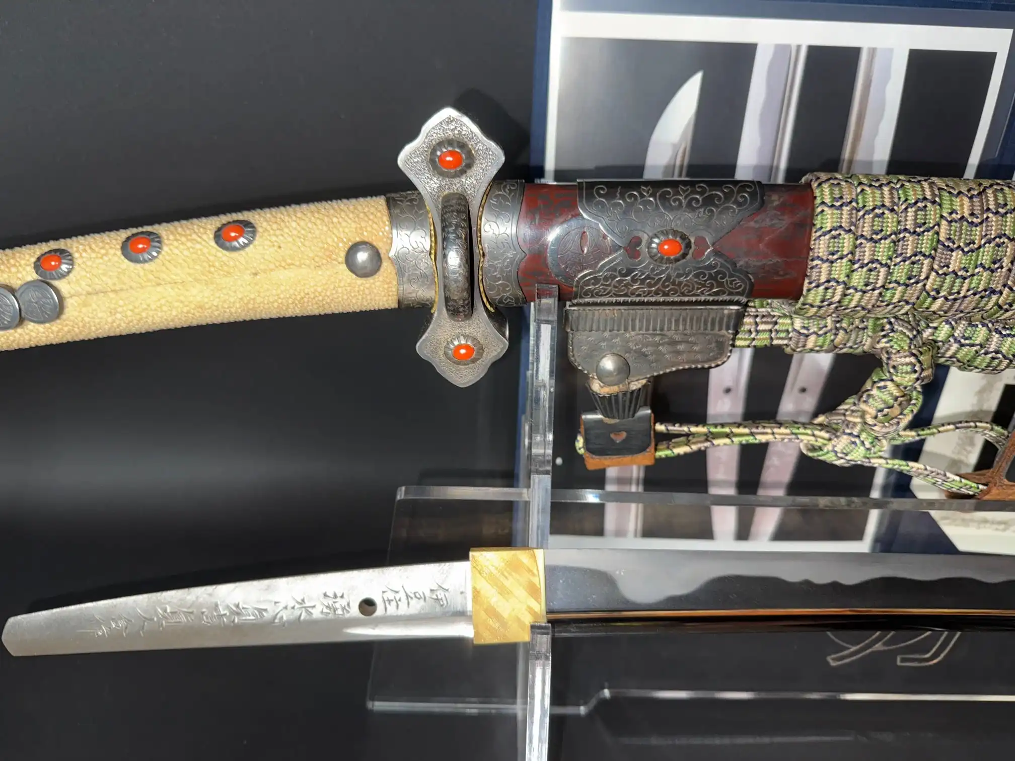 Close-up of a Tachi Katana Sadayoshi/Sadahito, showing detailed scabbard with red accents and partial blade.