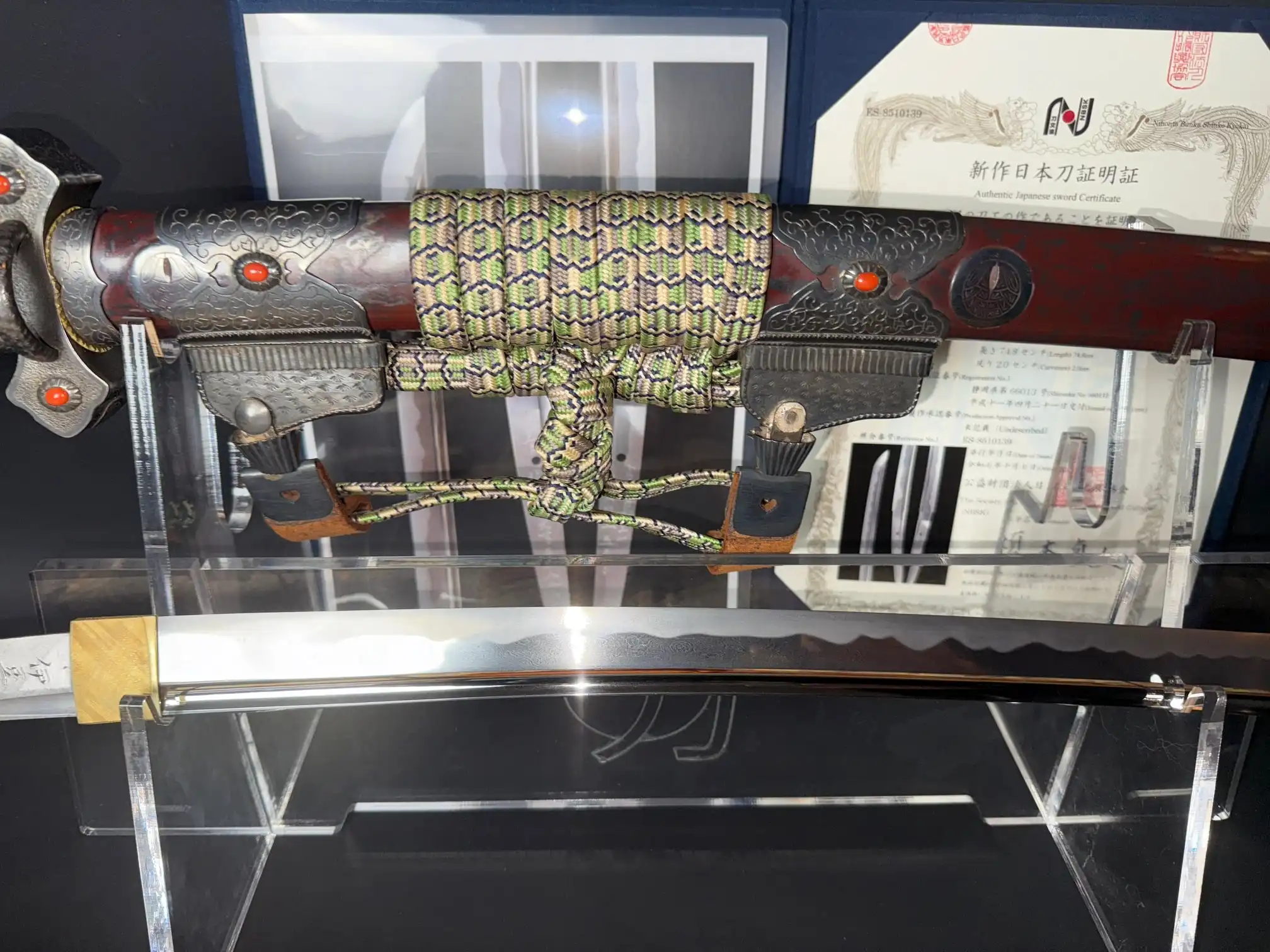 Display of Tachi Katana Sadayoshi/Sadahito sword, showing its ornate hilt, braided cord, and polished blade.
