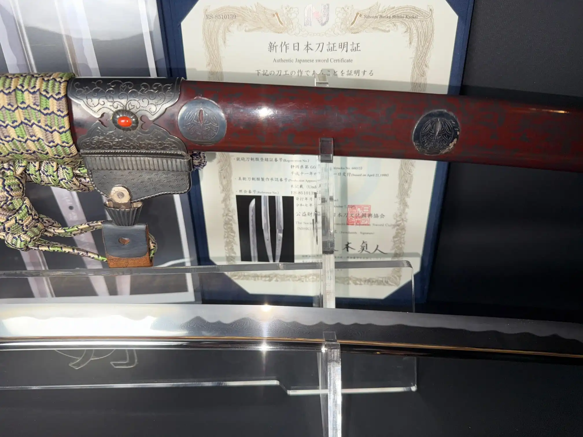 Close up of a Tachi Katana Sadayoshi/Sadahito, showing saya detail and a glimpse of the blade and certificate.