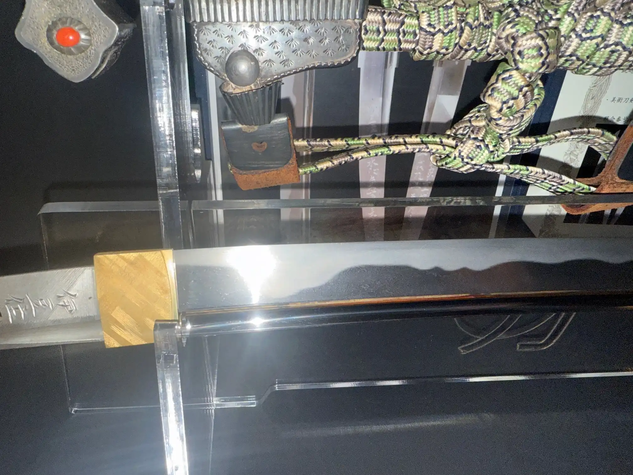 Close-up of a tachi Katana Sadayoshi/Sadahito blade with gold habaki and hamon visible, with tsuka partially shown.