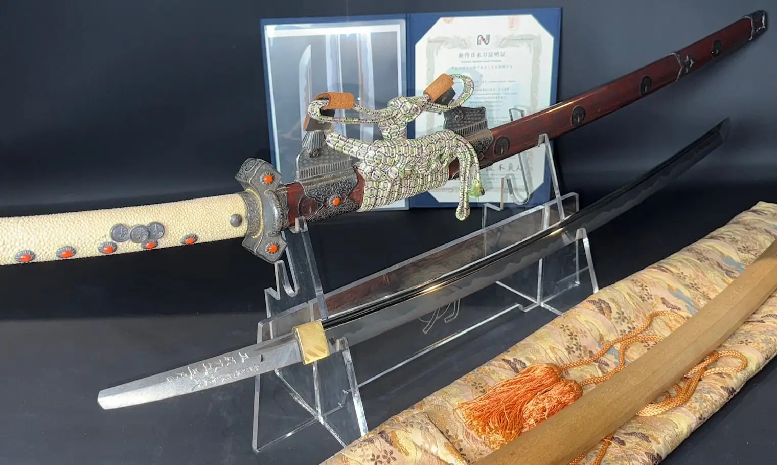 Tachi Katana Sadayoshi/Sadahito, a polished katana blade and its ornate saya and tsuka on display, angled