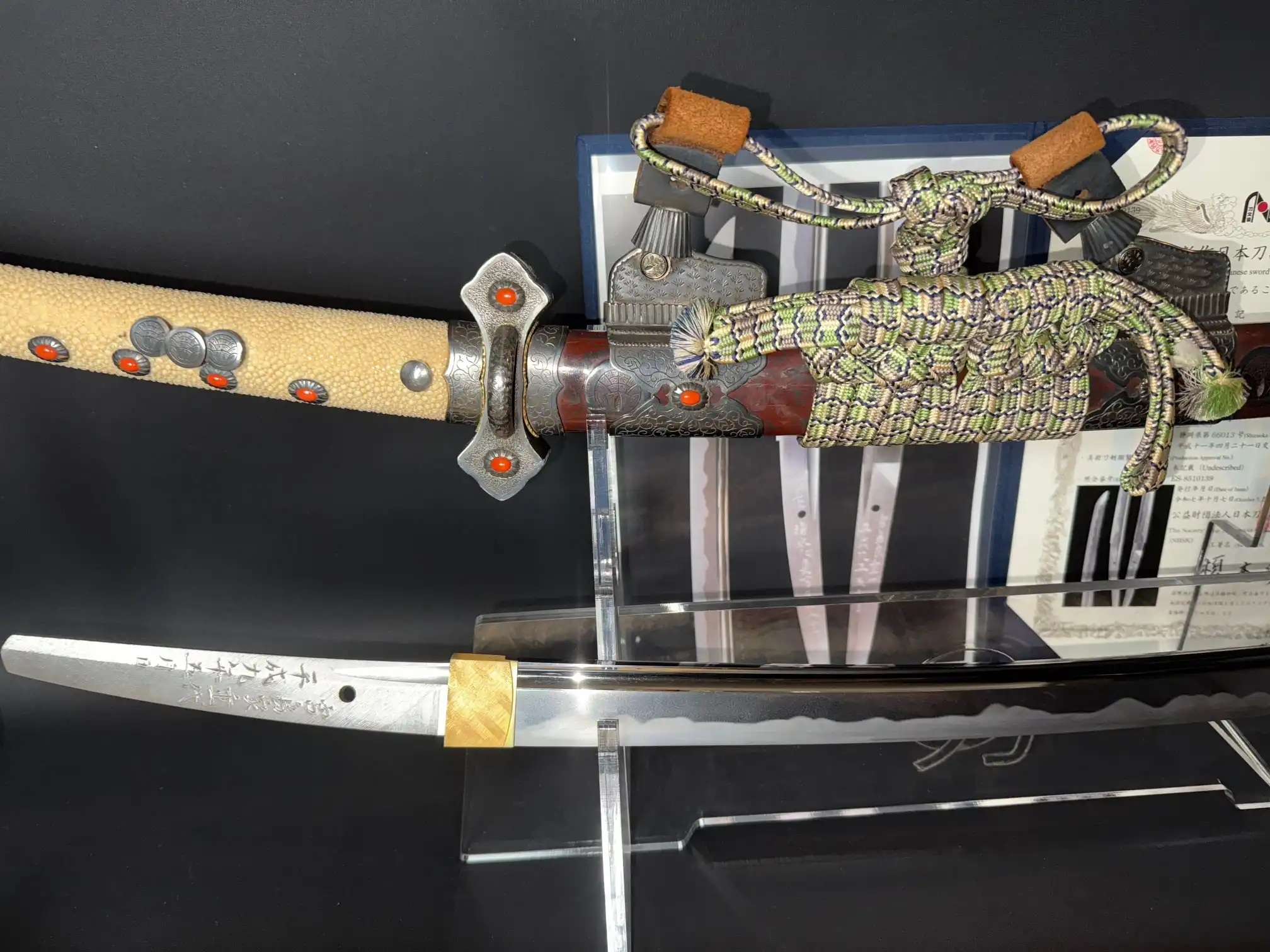 The Tachi Katana Sadayoshi/Sadahito, with ornate hilt and detailed blade, displayed on a stand.