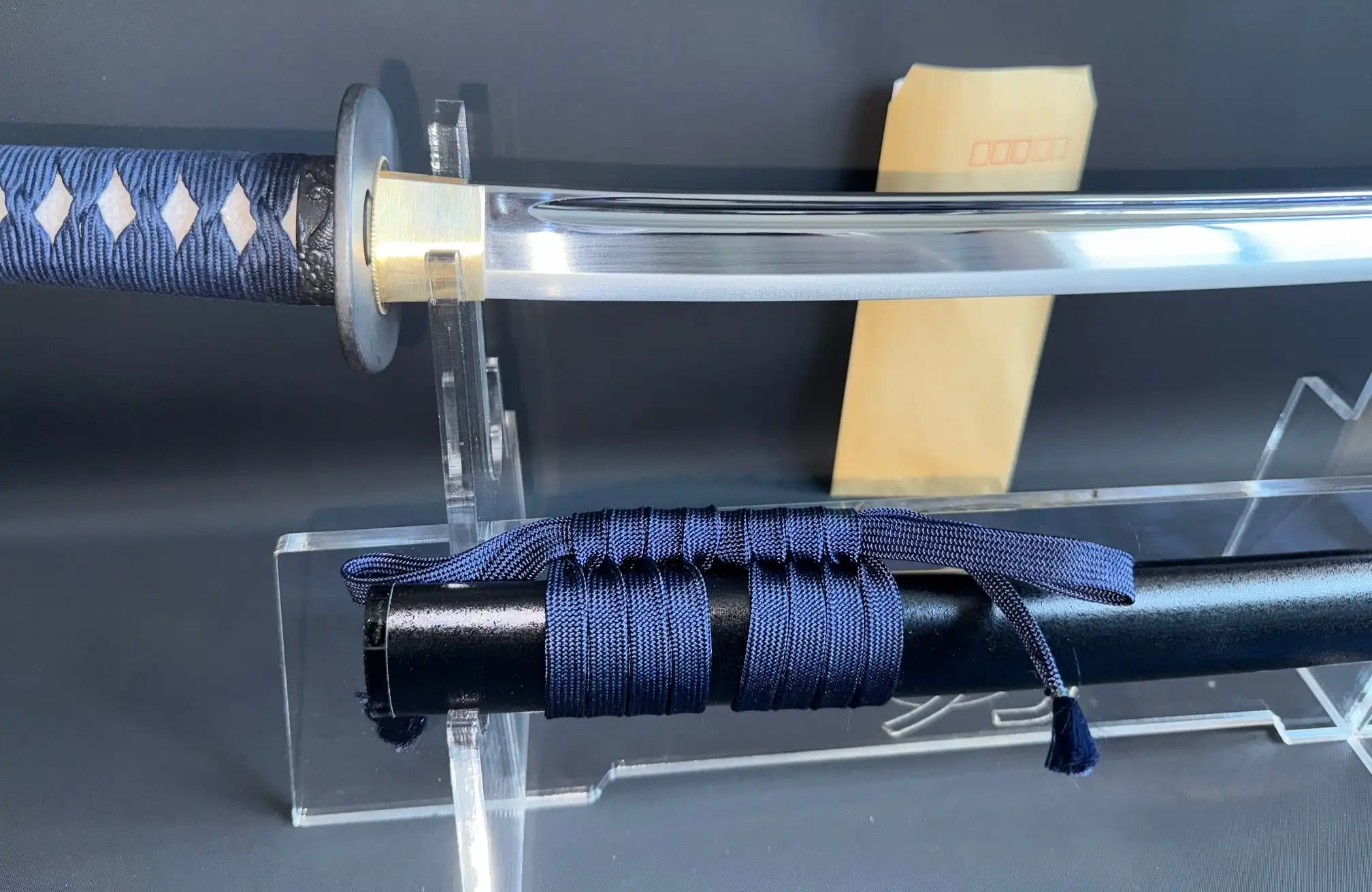 Close up of the IAITO MINOSAKA TOKUSEI Japanese Iaido sword with blue tsuka-ito and glossy blade