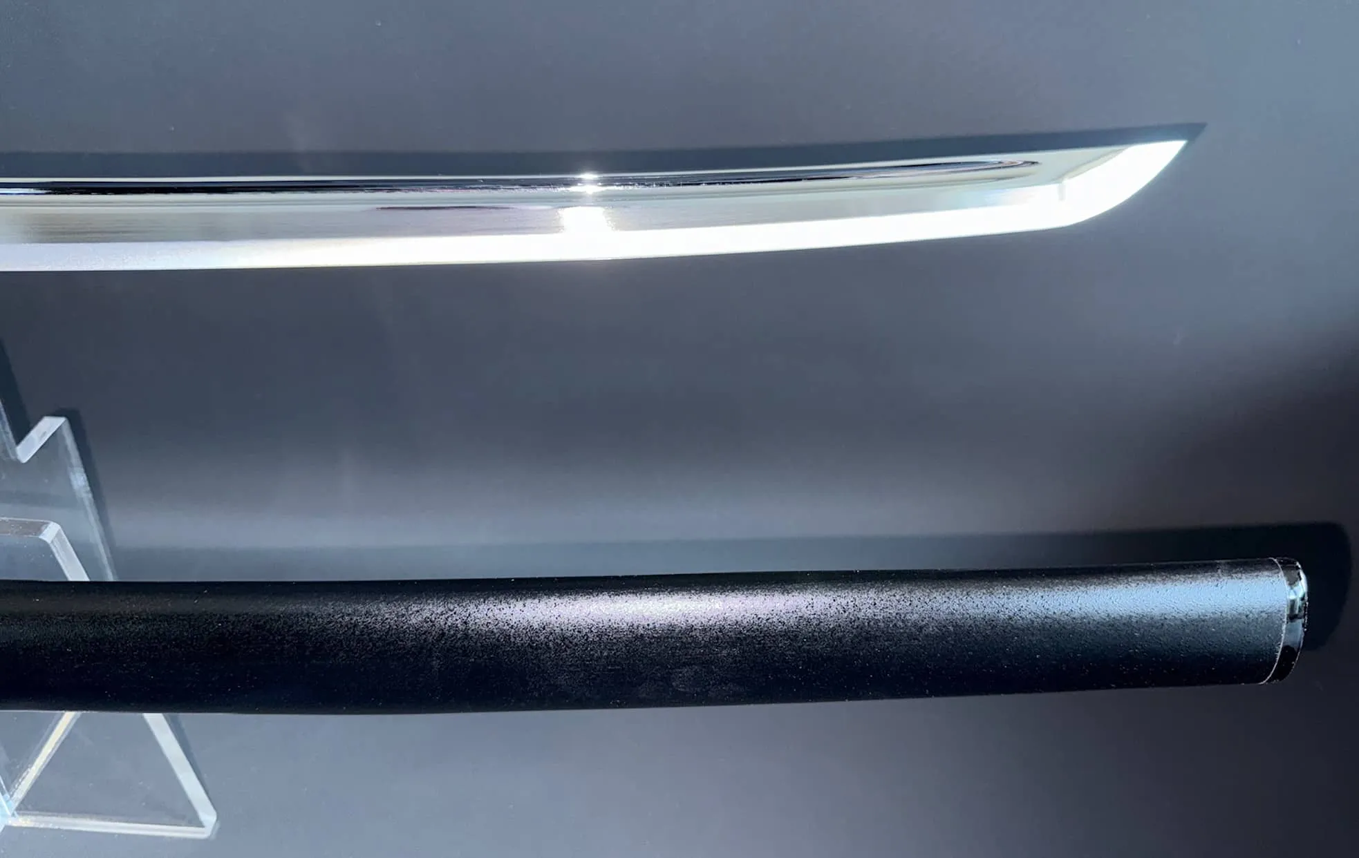 Top-down view of Japanese Iaido sword: IAITO MINOSAKA TOKUSEI, with polished blade above black saya