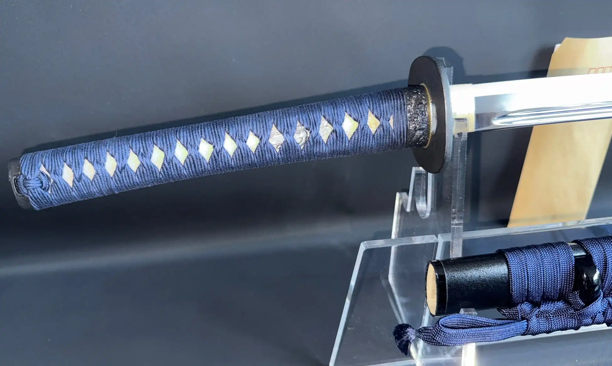 Close-up of a blue Japanese IAITO MINOSAKA TOKUSEI Iaido sword hilt with white diamond pattern