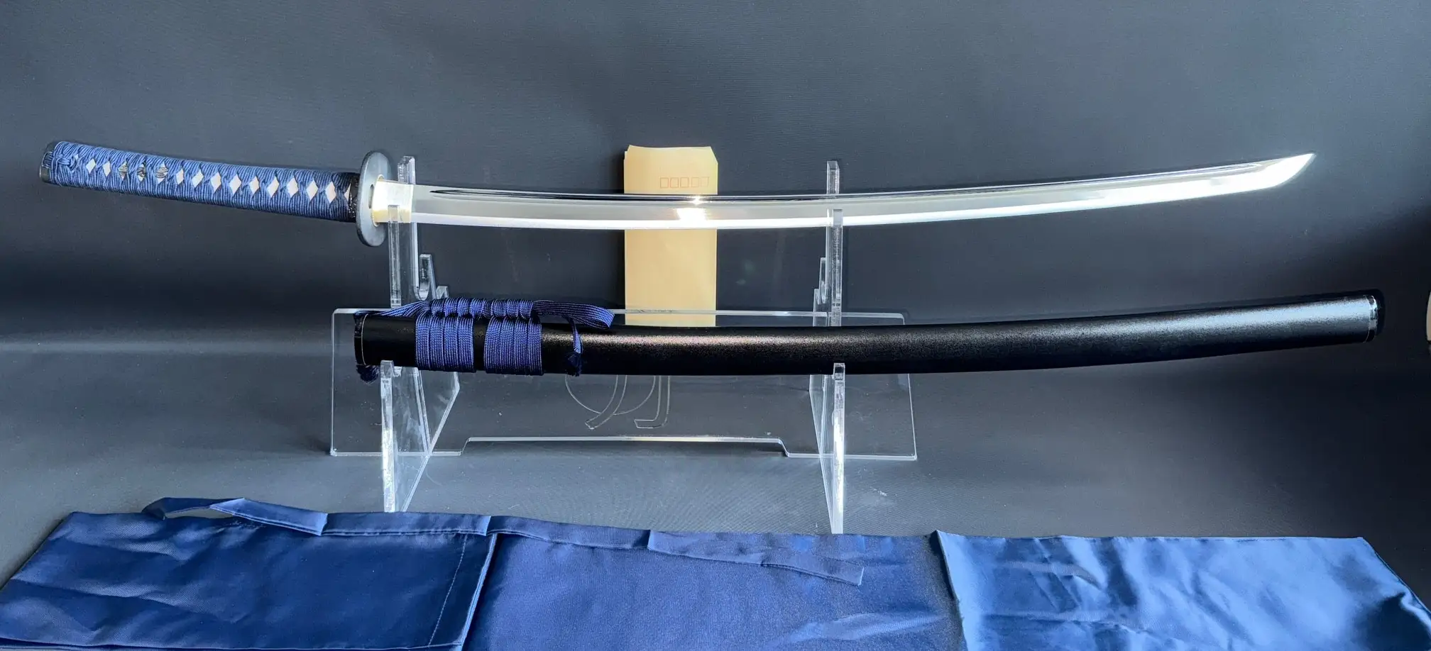 New IAITO MINOSAKA TOKUSEI Japanese Iaido sword with blue tsuka-ito and black saya on a stand